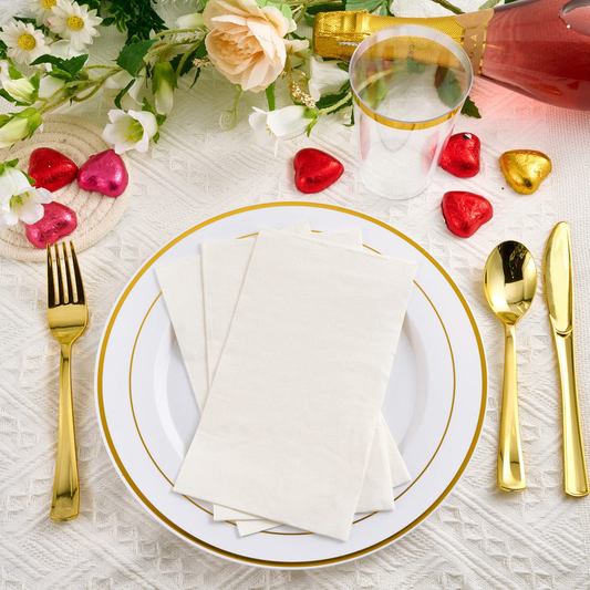 Elegant Jolly Chef table setting with a white plate, golden utensils, napkins, and heart-shaped candies, surrounded by flowers and a drink.