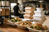 Takeout containers in a restaurant kitchen showing different food packaging sizes for delivery orders	