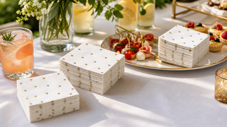 Gold polka dot paper cocktail napkins staged for drinks, appetizers, and desserts at a wedding