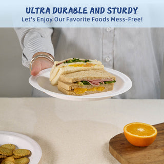 A person holds a jolly chef paper plate with a layered sandwich and an orange half on a table, promoting mess-free dining.