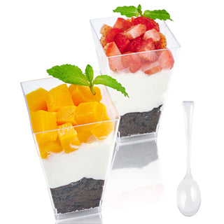 Two clear Jolly Chef dessert cups with layers of creamy white filling, crushed chocolate cookies, and topped with fresh mango and strawberries.