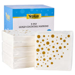 Stack of 3-ply gold polka dot cocktail napkins next to a box labeled 'Vplus 3-PLY GOLD COCKTAIL NAPKINS'.