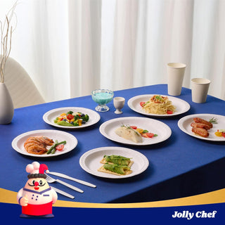 White paper plates with food: shrimp, salad, pasta, chicken, avocado. Blue tablecloth, chef figurine, beige cups.