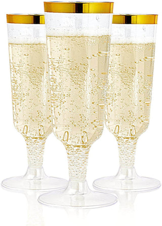 Three clear Jolly Chef 5oz Clear Gold Rim Easy Grip Champagne Flutes with gold rims filled with sparkling champagne bubbles.