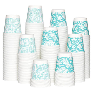 A stack of Jolly Chef 3oz Cloud Pattern Paper Cups featuring alternating blue and white swirl and cloud patterns, arranged in  an artistic mound.