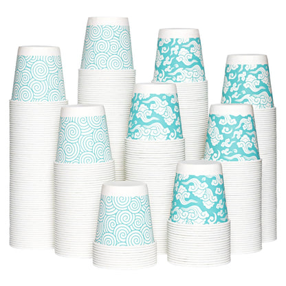 A stack of Jolly Chef 3oz Cloud Pattern Paper Cups featuring alternating blue and white swirl and cloud patterns, arranged in  an artistic mound.