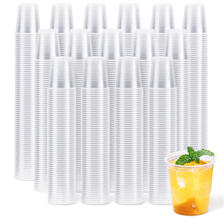 A stack of Jolly Chef Clear Plastic(PP) Cups in the background with a refreshing drink in a cup, garnished with mint, in the foreground.