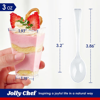 A hand holds a Jolly Chef 3 oz clear plastic dessert cup with layered pink and yellow dessert, strawberry garnish, and size markings (1.97", 1.19"), alongside a clear plastic spoon with its dimensions (3.2", 3.86"), branded with Jolly Chef — Inspiring a joyful life in a natural way