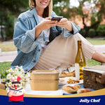 Stack of 19oz kraft paper food containers with clear lids, perfect for salads or pasta, on a picnic blanket.