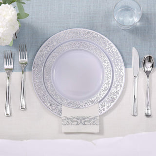 Elegant table setting with silver charger plate, white dinnerware, and cutlery.
