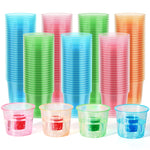 Colorful 4oz jager bomb cups stacked, with four in front filled with colored shots and bubbly liquid.