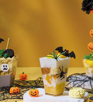 Halloween dessert parfait with bat and spider decorations.