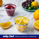 Clear plastic cups with silver rims filled with dragon fruit and orange segments, with assorted fruits in background.