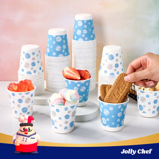 A variety of colorful eco-friendly JOLLY CHEF 5 oz Paper Cups, stacked and filled with treats, displayed on a wooden serving board.