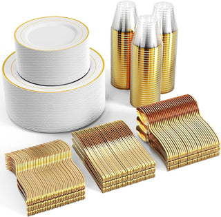 Gold-rimmed white plates, gold plastic cups, forks, knives, and spoons stacked for a party.