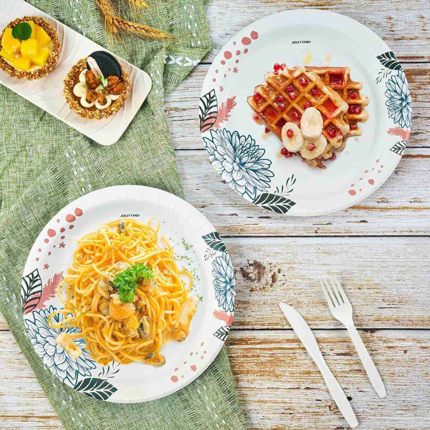Jolly Chef blog content from February 2025 Jolly Chef floral-patterned plates hold pasta, waffles, and desserts, paired with utensils on a rustic wooden table and green fabric.