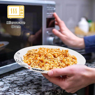 A hand is placing a jolly chef plate of rice and chicken near a microwave oven, preparing to heat the meal.
