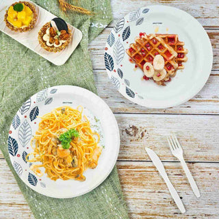 A jolly chef plate of creamy seafood pasta with parsley, a waffle topped with banana and sauce, and mango dessert on a green cloth.